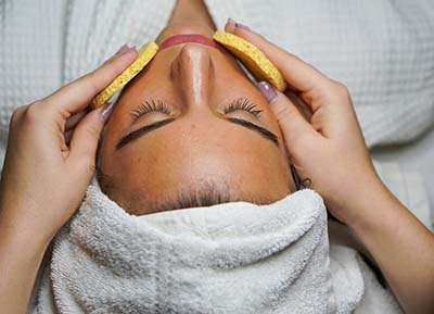Limpieza facial profunda a mujer acostada
